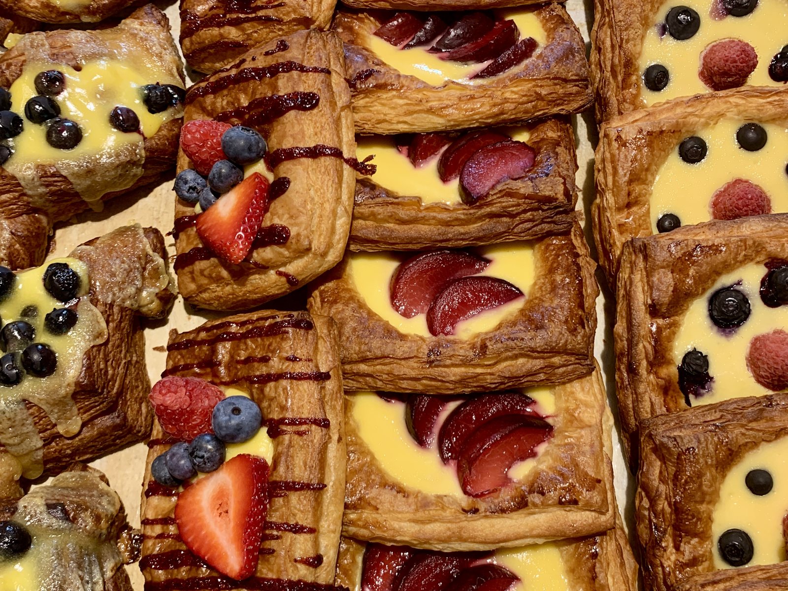 A full tray of assorted berry and custard danishes