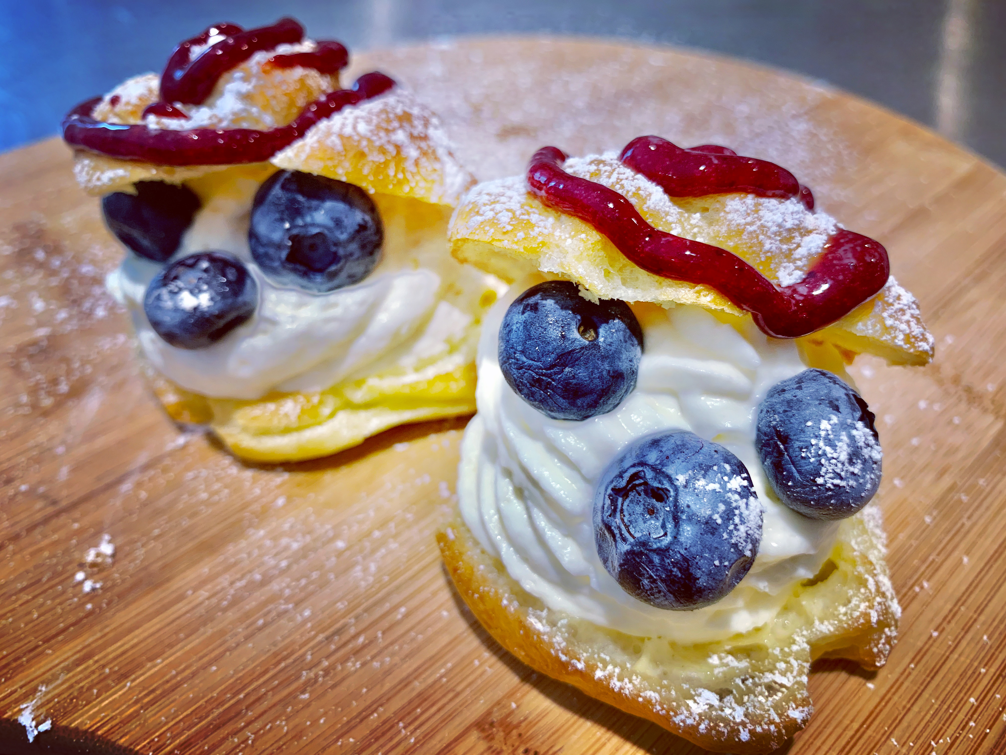 Cream puffs filled with vanilla cream and topped with blueberries