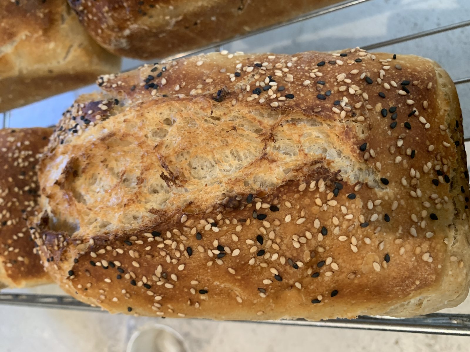 A sourdough loaf topped with black and white sesame seeds